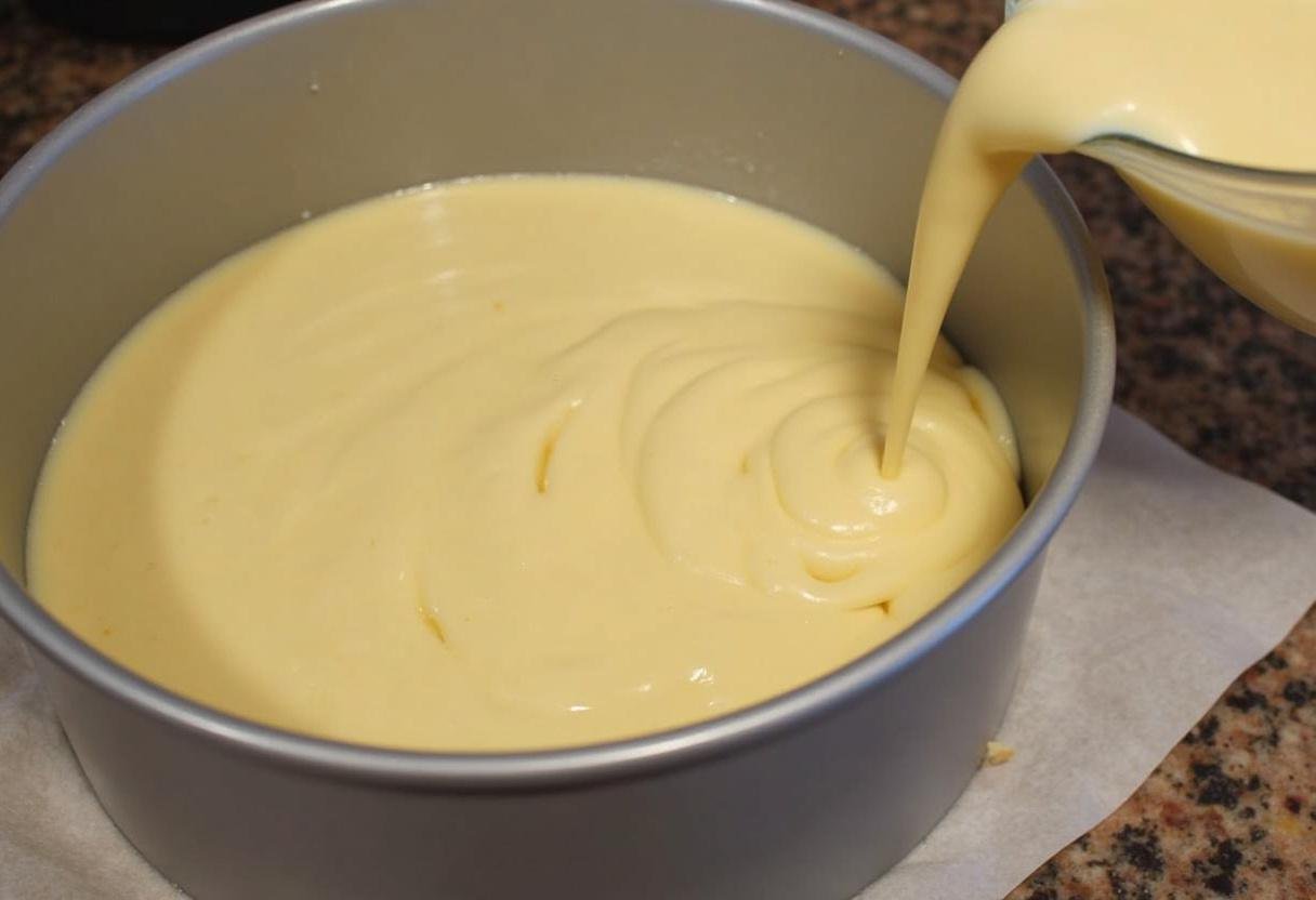 Verser la pâte du gâteau à l'avoine et au yaourt dans un moule préparé, prêt pour une cuisson saine.