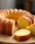 Afficher le gâteau idéal pour le petit déjeuner, doré et tranché, sur une table en bois, prêt à être dégusté.
