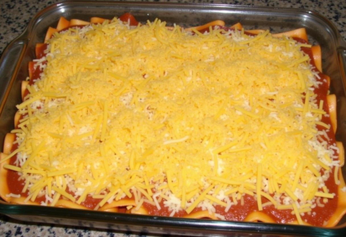 Assemblage des lasagnes au potiron avec des couches de pùte, de purée de potiron et de fromage.