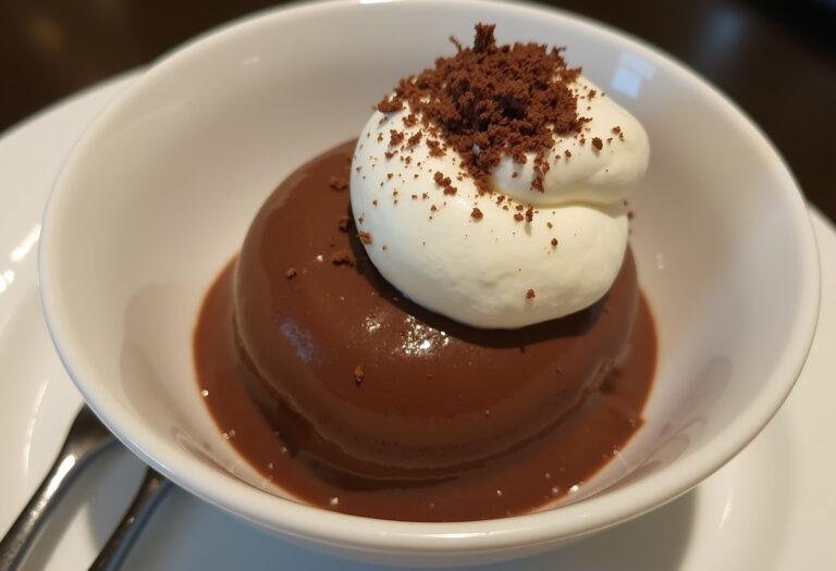 Déguster une mousse au chocolat 2 ingrédients présentée avec de la crÚme fouettée et des copeaux de chocolat.
