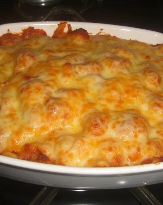 Présentation d'un plat de pâtes au fromage gratinées au four, montrant un gratin doré avec une croûte de fromage fondue délicieuse.