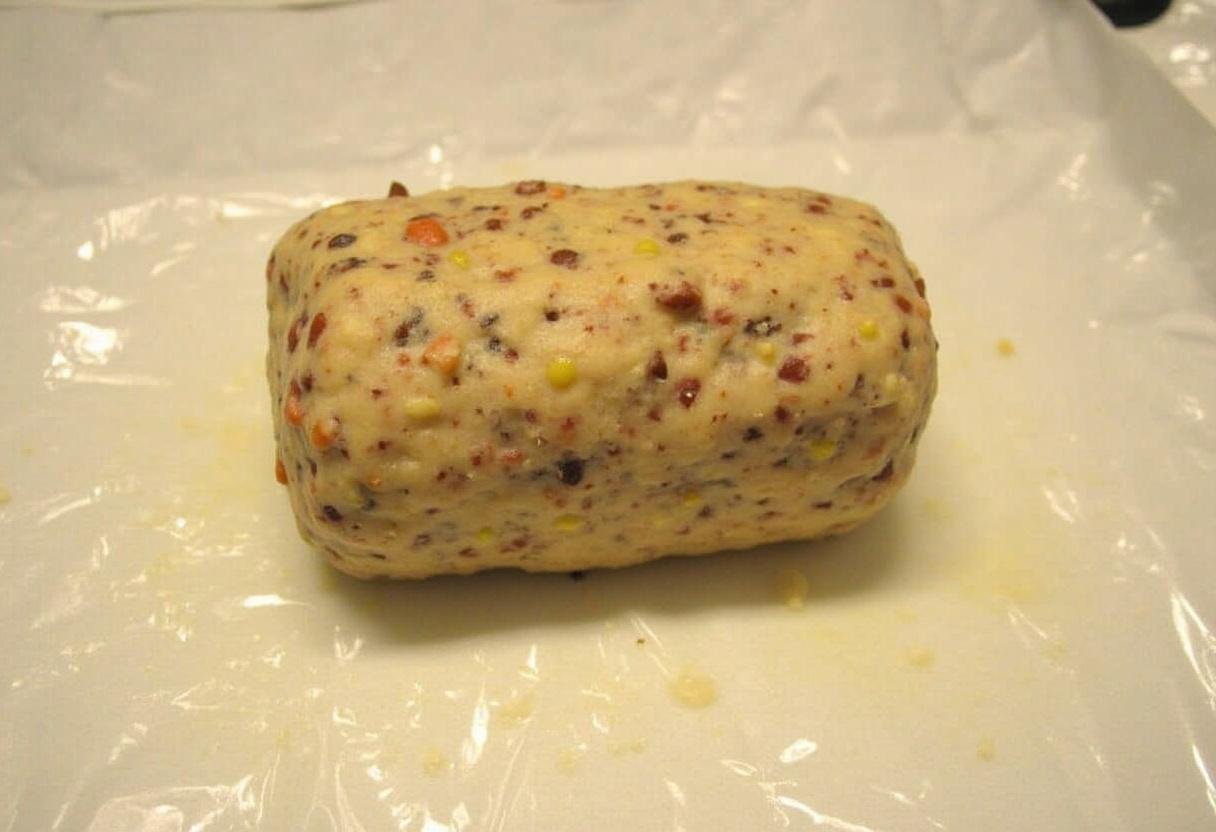 Formation d'un rouleau à partir du mélange de chocolat et de biscuits pour la recette saucisson au chocolat.